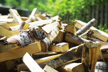 Firewood in a pallet. Chopped firewood lies on the ground. Wooden background..