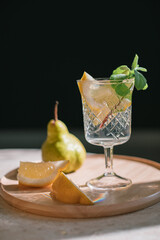 Glass of fresh cool lemonade with lemon and mint leaves on wooden tray. 