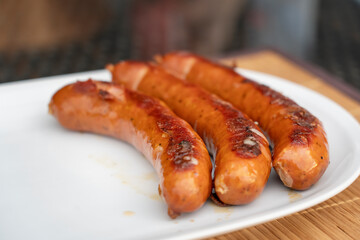 Burned Juicy sausage barbecue Sizzle on with Salt and Black Peppers on White Plate for Lunch BBQ Grilled for Picnic