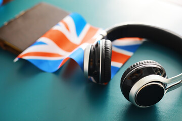 Headphones and flag. The study of foreign subjects. Audiobooks in a foreign language. Language classes. Listening.