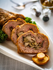 Stuffed pork minced meat with mushrooms on wooden table
