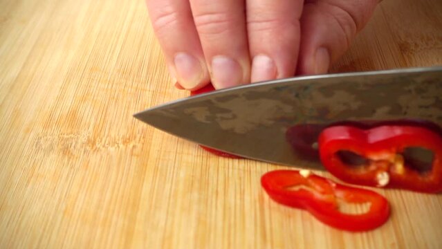 The cook cuts the capi pepper with a knife. Slow motion.
