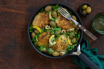 roasted chicken thigh with lemon and olives on pan