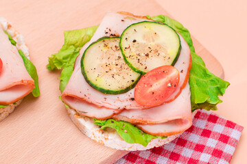 Light Breakfast. Quick and Healthy Sandwiches. Rice Cake with Ham, Tomato, Fresh Cucumber and Green Salad on Wooden Cutting Board