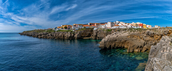 Obraz premium panorama view of the jagged rocky coast and colorful houses in the center of Peniche