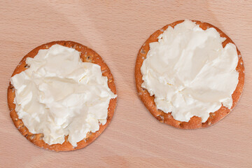 Crispy Cracker Sandwich with Cream Cheese on Wooden Cooking Board on Magenta Background