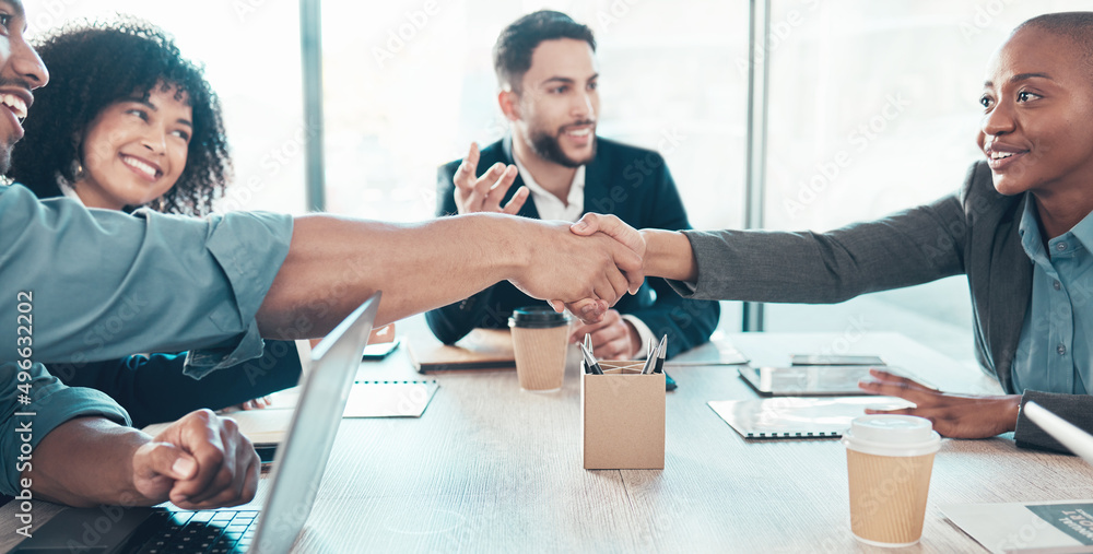 Wall mural Its official now. Shot of a diverse group of businesspeople sitting in the office together and shaking hands during a meeting.