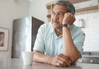Being alone gets lonely. Shot of a senior man looking pensive while drinking coffee at home.