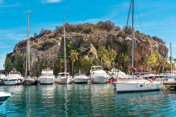 Fototapeta na wymiar Bay area situated in la provincial de Granada. Beautiful harbour with luxury yachts docked in a small bay. All the dock area surrounded by restaurants