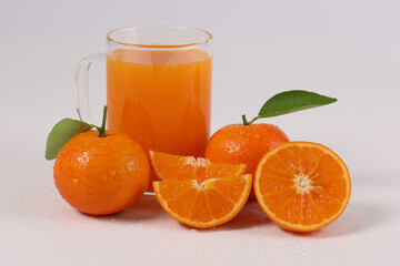 oranges, halved oranges, healthy fruit, mandarin oranges, orange juice in glass, vitamin C, against a white background with refreshing drops of water