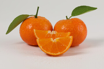 oranges, halved oranges, healthy fruit, mandarin oranges, vitamin C, against white background with refreshing water droplets