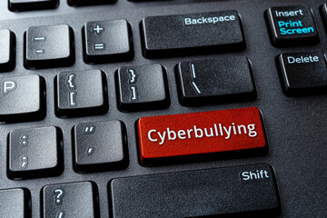 Cyberbullying word on a computer keyboard button. Laptop enter key with message cyberbullying....