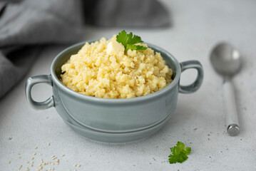 boiled millet porridge with butter and sesame seeds in a gray plate