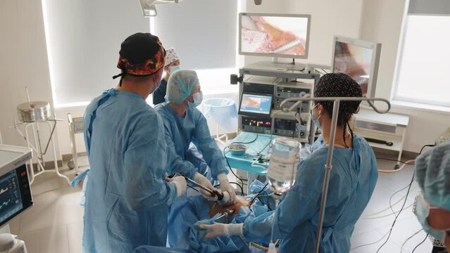 Operation using laparoscopic equipment. Process of gynecological surgery operation using laparoscopic equipment. Group of surgeons in operating room with surgery equipment