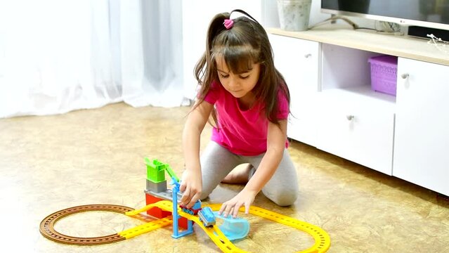 baby game. Little clever caucasian child playing colorful toy railway and train for early development.