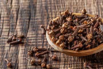 The carnation is on a spoon and laid out on a dark wood 