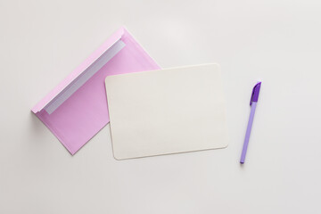 Violet envelope with blank paper and pen, greeting card or invitation mockup, top view, copy space