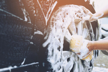 people worker man holding hand yellow sponge and bubble foam cleanser window for washing car. Concept car wash clean. Leave space for writing messages.