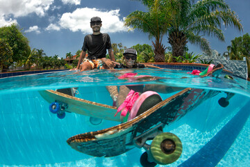 Man and Woman skateboarding  in the swimming pool.