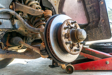 Replace brake disc and pads Front Disk brake assembly on an old car - Brake job in progress.