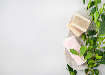Concept flat lay of facial and body care cosmetics with  soap and towel  on white  background with brunch. Top view and copy space