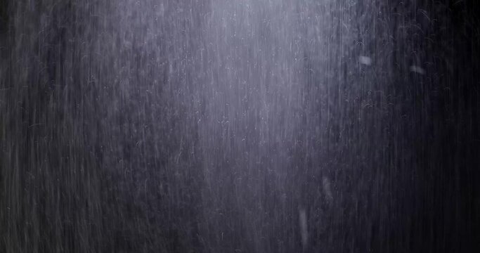 Water Drops following down on the black background. Drops of rain trickling down isolated. Best 4K footage Droplets of Water on Black Glass running down. Perfect for digital composing.