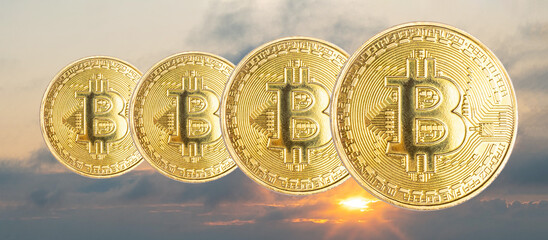 bitcoin coins on the background of the sunset sky with the sun