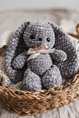 Obraz premium Knitted bunny of gray color in the interior of a bright apartment