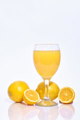 Whole and sliced lemon slices with a glass of squeezed juice
