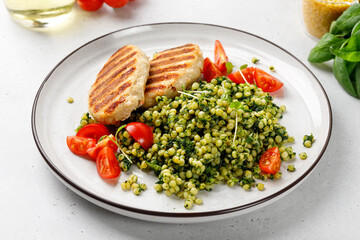 Homemade Ptitim with two cutlets. Ptitim or Israeli couscous, toasted paste. Made with broccoli, tomato and spinach.