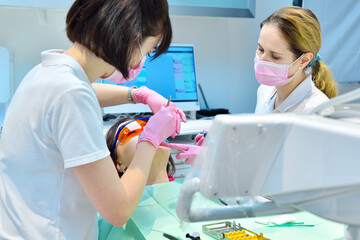 Dentist prepares woman patient for teeth whitening procedure