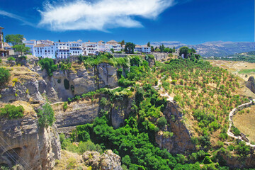 Panoramic view on ancient village Ronda located precariously close to the edge of a cliff, rural agriculture landscape background - Andalusia, Spain
