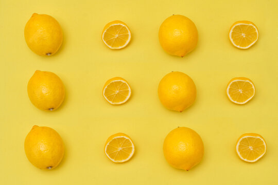 Lemon with halves and whole ripe lemons on yellow background © joycedragan