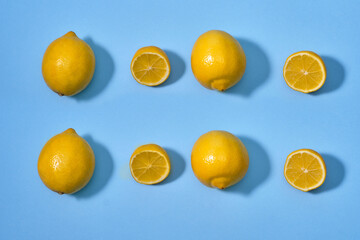 Lemon with halves and whole ripe lemons on blue background