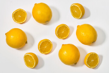 Lemon with halves and whole ripe lemons on white background
