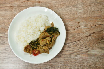 spicy fried slice kurobuta black pork with basil on rice in plate