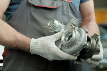 A turbine for an automobile engine in the hands of an auto mechanic. Maintenance and repair in a...