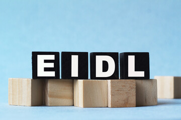 Wooden cube block with text EIDL on blue background