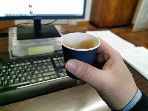 Pausa caff&egrave; al lavoro on ufficio, un momento di relax davangi alla propria scrivania e computer