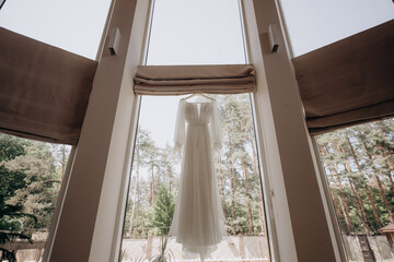 wedding dress hanging on the panoramic window