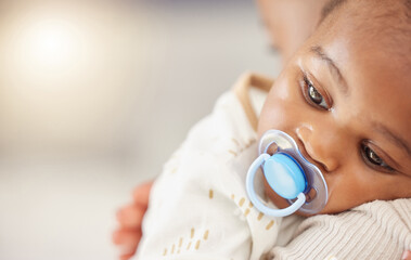 Shes my little miracle, my whole world. Shot of an adorable baby girl sucking a dummy while being...