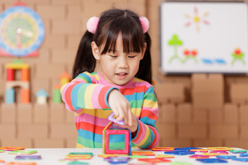 young girl playing creative toy blocks at home
