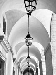 Old lantern lamps aligned under arches