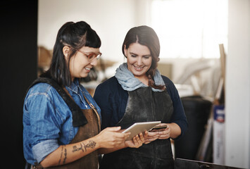 Here are the new designs. Cropped shot of two attractive young creative female artisans working on a tablet in their workshop.