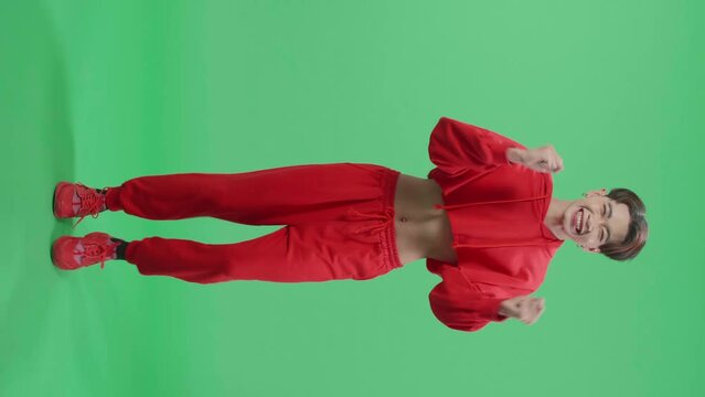 Full Body Of The Surprised Asian Transgender Male Positively Shaking His Head And Pressing His Hands To Her Face To The Camera In Green Screen Studio
