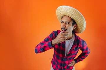 Black Man With Junina Party Outfit  Isolated on Orange Background. - obrazy, fototapety, plakaty