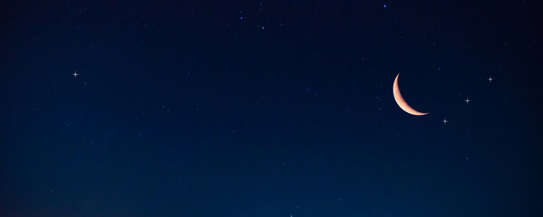 Amazing crescent moon on dark blue night sky background, universe full of stars, nebula and...