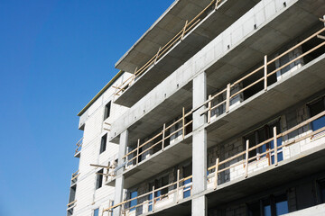 Luxurious apartments for sale. Bricks and concrete. Construction site background. High block of...