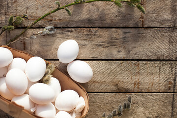 Few white eggs in   basket on   wooden background.