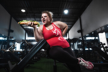 Sport with unhealthy food. combination of active life with fast food. close up photo. Fat woman...